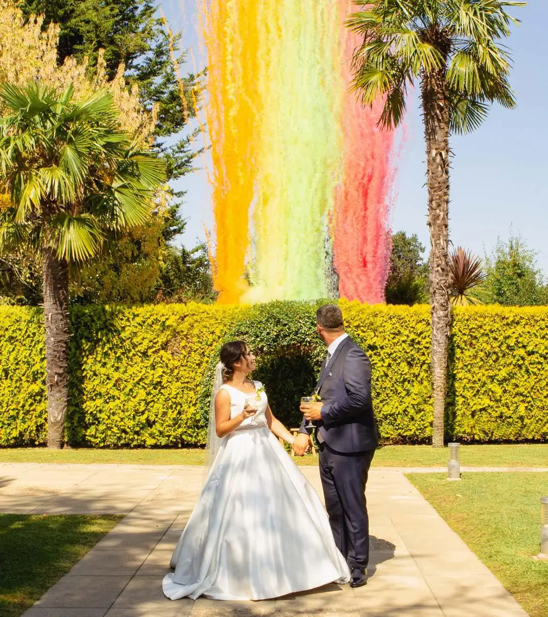Disparo de fumos coloridos da Joca Animação durante casamento ao ar livre, criando um efeito visual vibrante.