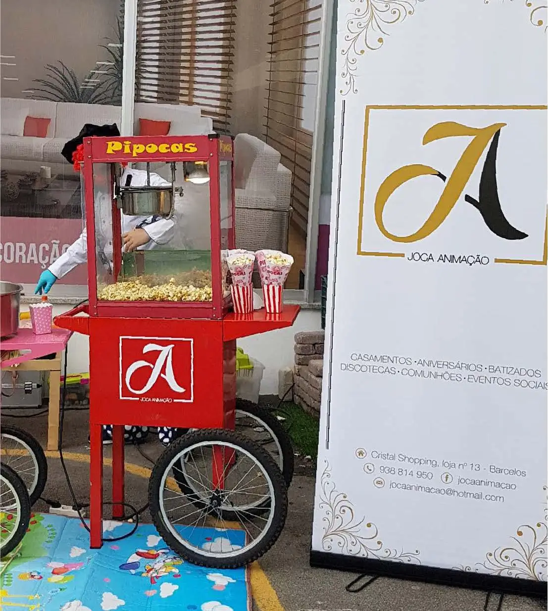 Máquina de pipocas da Joca Animação com carrinho vermelho vintage, ideal para animar eventos com snacks deliciosos.