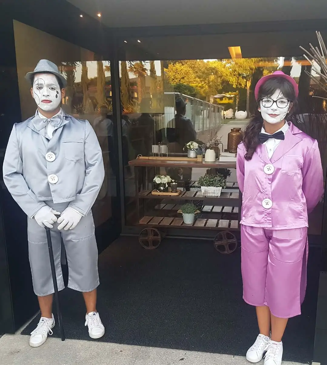 Artistas mimos caracterizados como estátuas vivas a receber convidados, representando performances elegantes da Joca Animação.