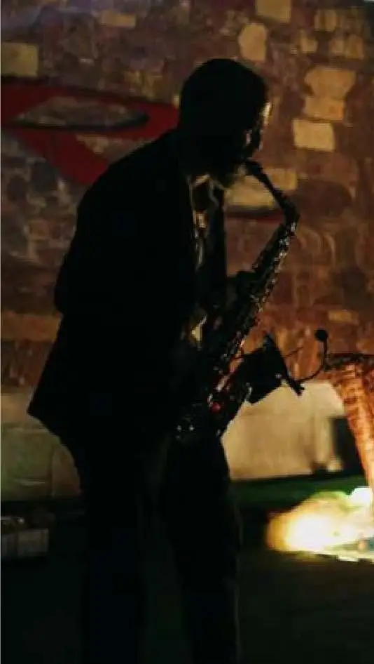 Saxofonista a tocar ao vivo durante um evento noturno, parte da animação musical da Joca Animação.